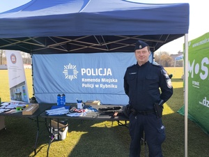 Policjant przy policyjnym namiocie.