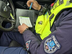 Na zdjęciu policjant wypisuje dokumentacje.