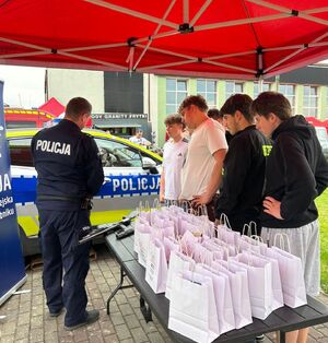 Na zdjęciu policjant oraz uczestnicy akcji charytatywnej.