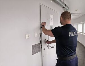 Na zdjęciu policjant w aresztach.
