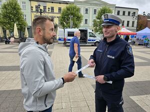 Na zdjęciu policjant rozdaje odblaski podczas akcji.